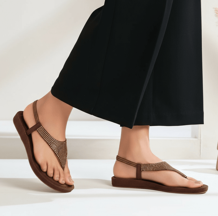 Brown studded flat sandals with realistic legs and props